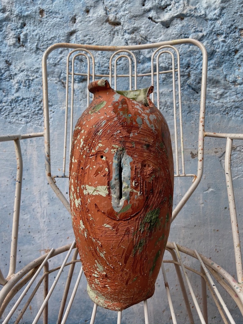 Iván Forcadell, escultura de terracota marrón sobre silla de jardín