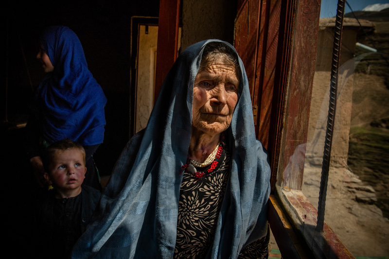 premio leica oskar barnack loba 2022: anciana con pañuelo en la cabeza mirando por la ventana