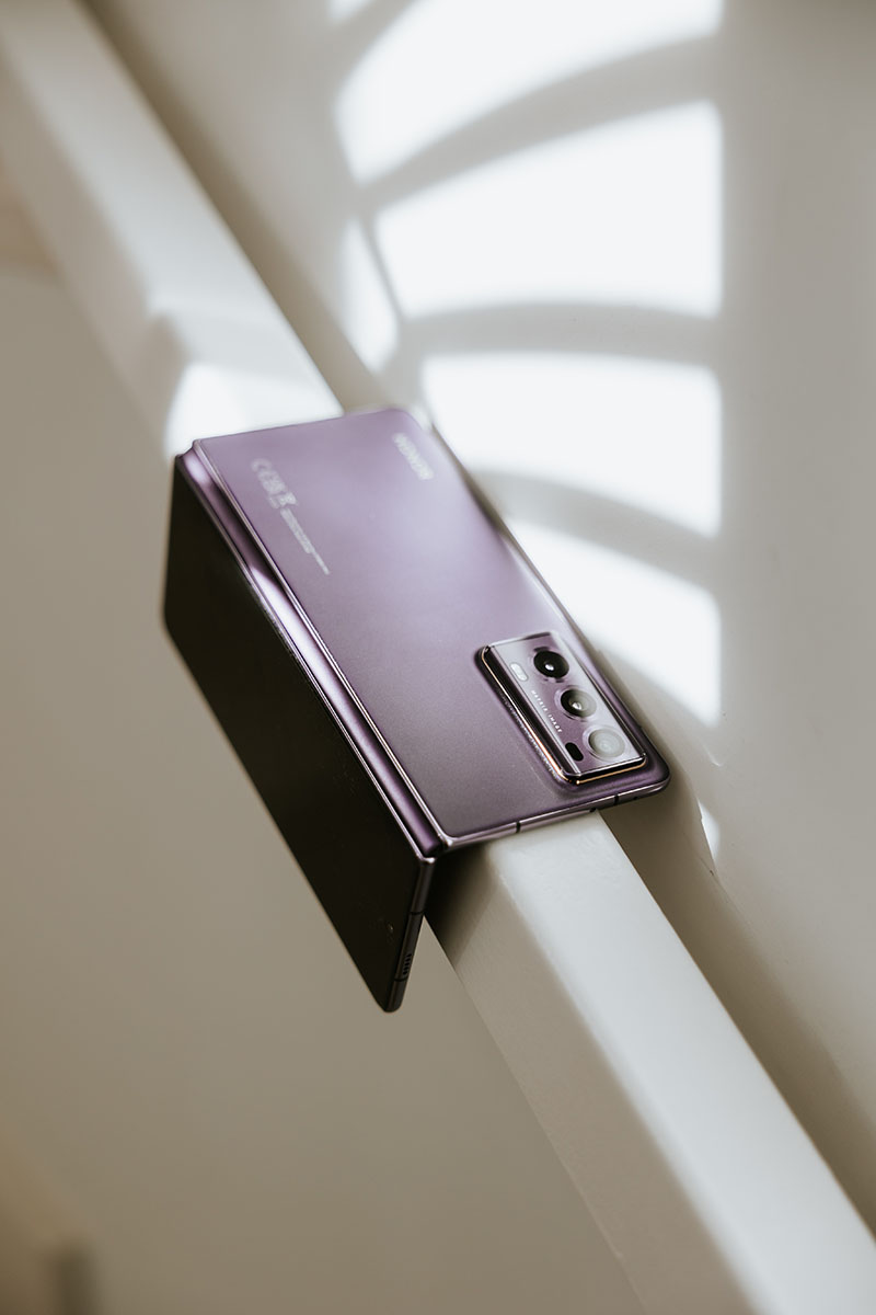 Honor Magic V2: fotografía que muestra cómo se ve el nuevo smartphone un poco plegado en color púrpura.