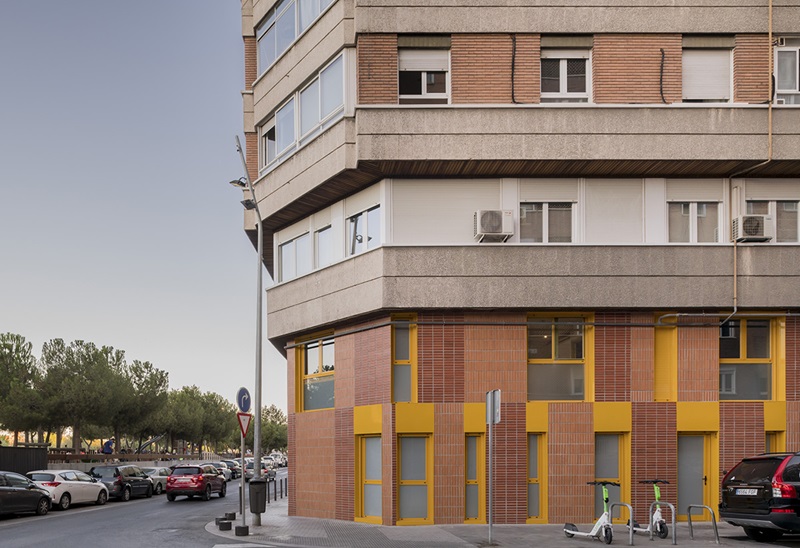 OOIIO-Arquitectura-Apartamentos-Man: fachada de ladrillo con marcos amarillos