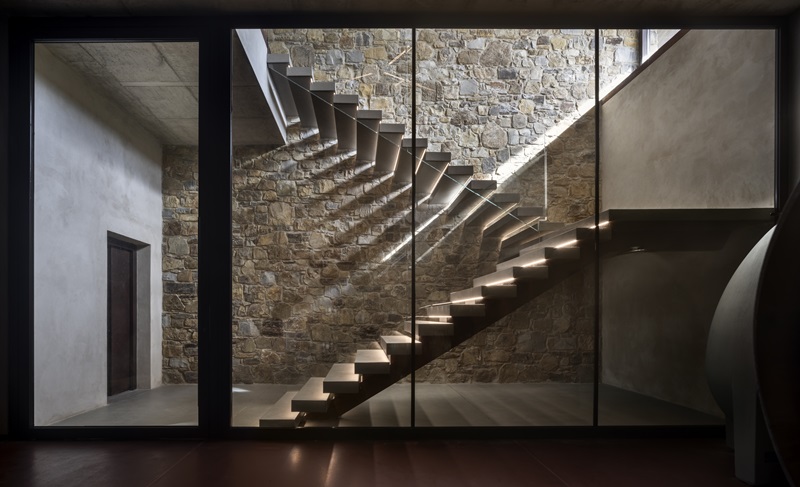 Ubik-Architecture-tenuta-il-quinto: escalera de entrada flanqueada por un muro de piedra 