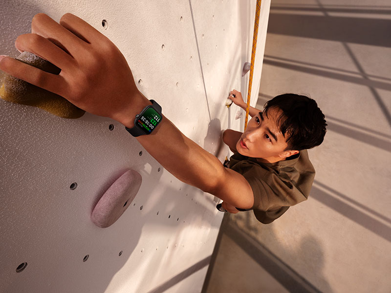 Huawei Watch Fit 3: un joven escalando con la mano y el rejoj en primer plano