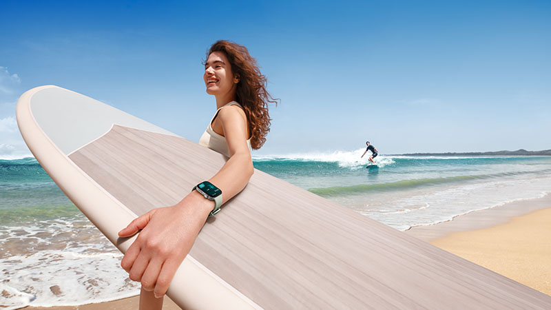 Huawei Watch Fit 3: una chica haciendo surf con el reloj en la mano