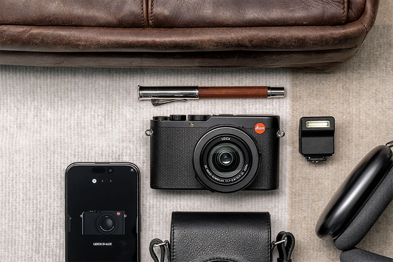 Leica D-Lux 8 nueva y asequible lámpara compacta. Bodegón con la cámara y varios objetos