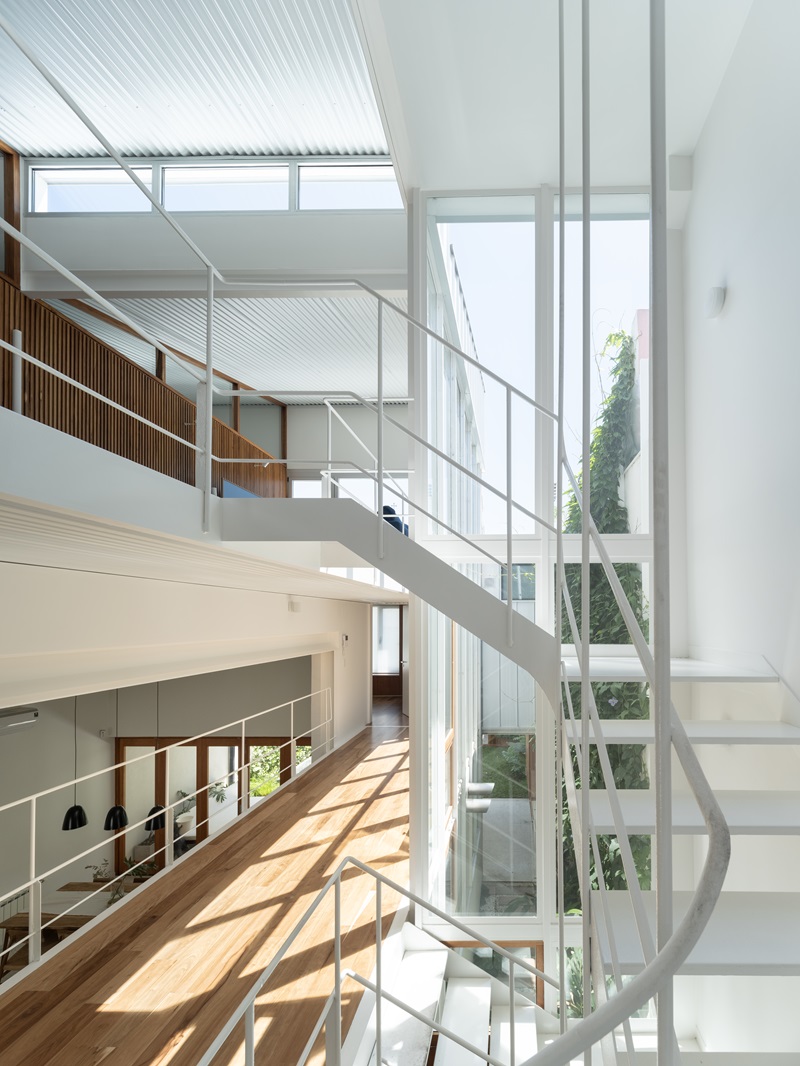 Estudio-Damero-Casa-Planes: escalera metálica blanca con vistas al patio de luz