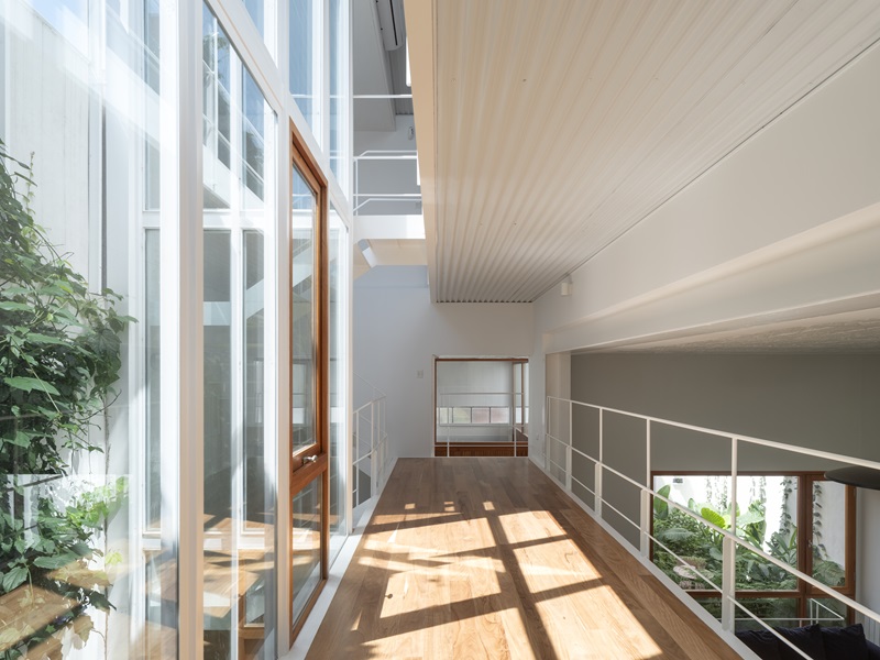 Estudio-Damero-Casa-Planes: corredor con vistas a la zona de día y al patio de luz