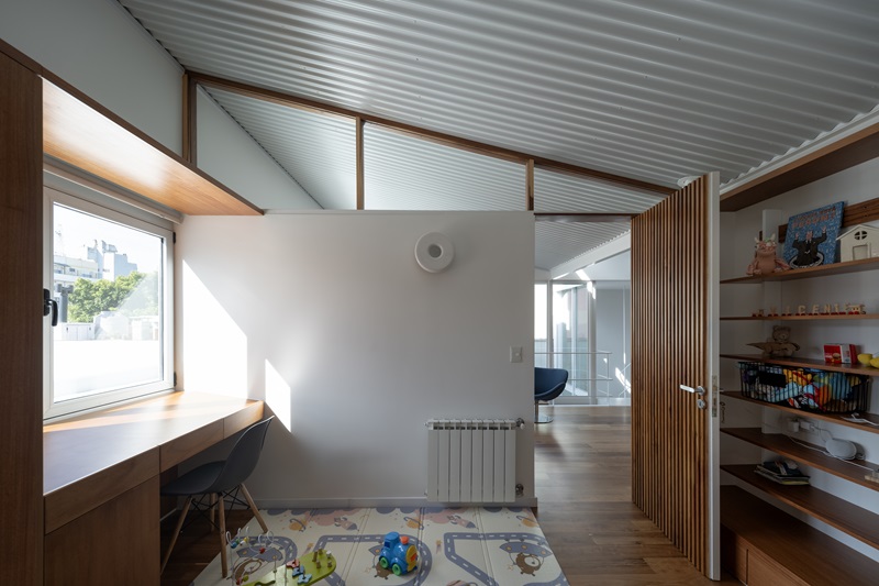 Estudio-Damero-Casa-Planes: habitación infantil con techo en diente de sierra