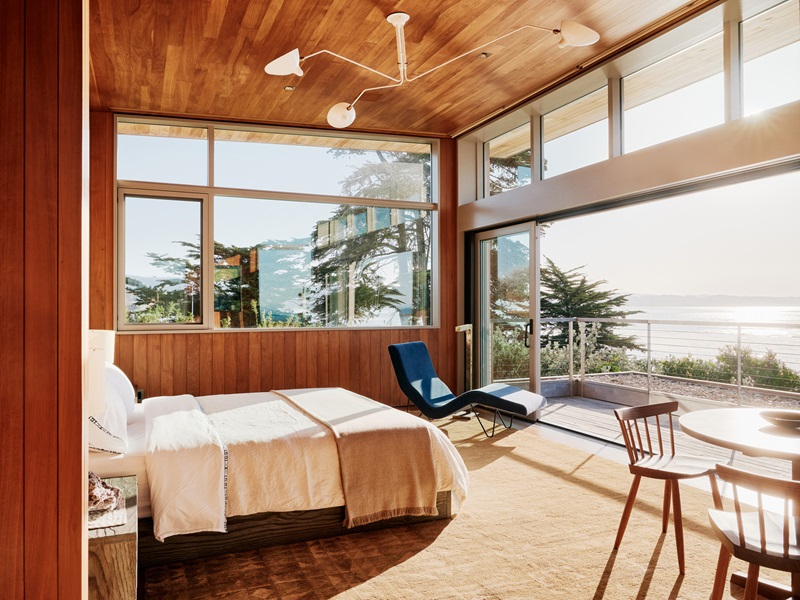 Feldman Architecture-Surf-House: dormitorio de madera con balcón al mar y ventanales de suelo a techo