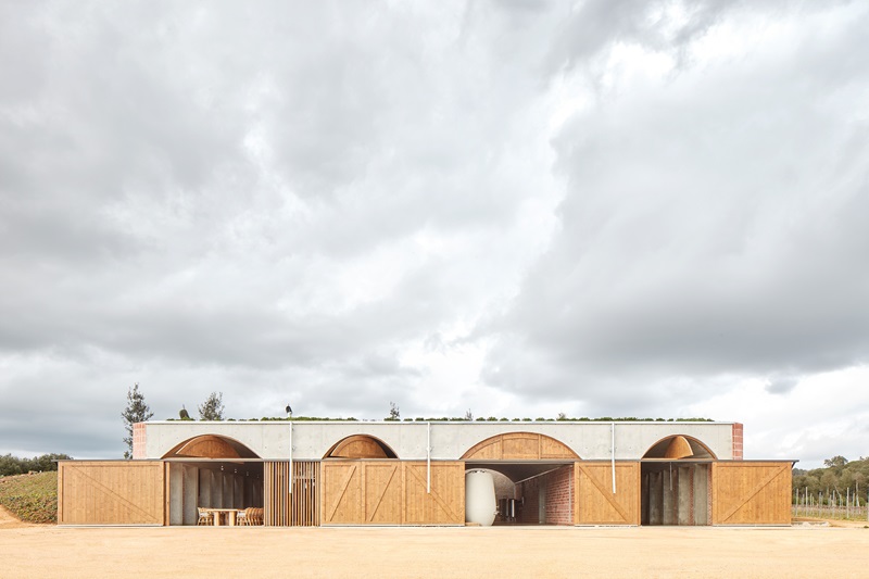 Jorge-Vidal-Studio-Bodega-Mont-Ras: vista de la bodega con puertas de madera abiertas