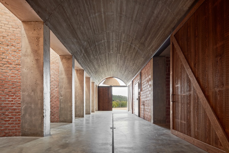 Jorge-Vidal-Studio-Bodega-Mont-Ras: nave interior con bóveda y muro de ladrillos