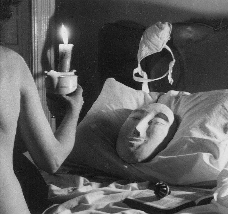 Loewe - Centenario Surrealista - foto en blanco y negro, se ve unbrazo de mujes sujentando una vela y en una almohada una máscara
