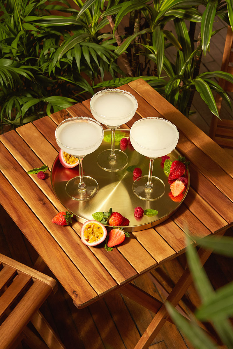 Cómo hacer cócteles sencillos para el verano: varias copas de Margaritas frozen en un jardín
