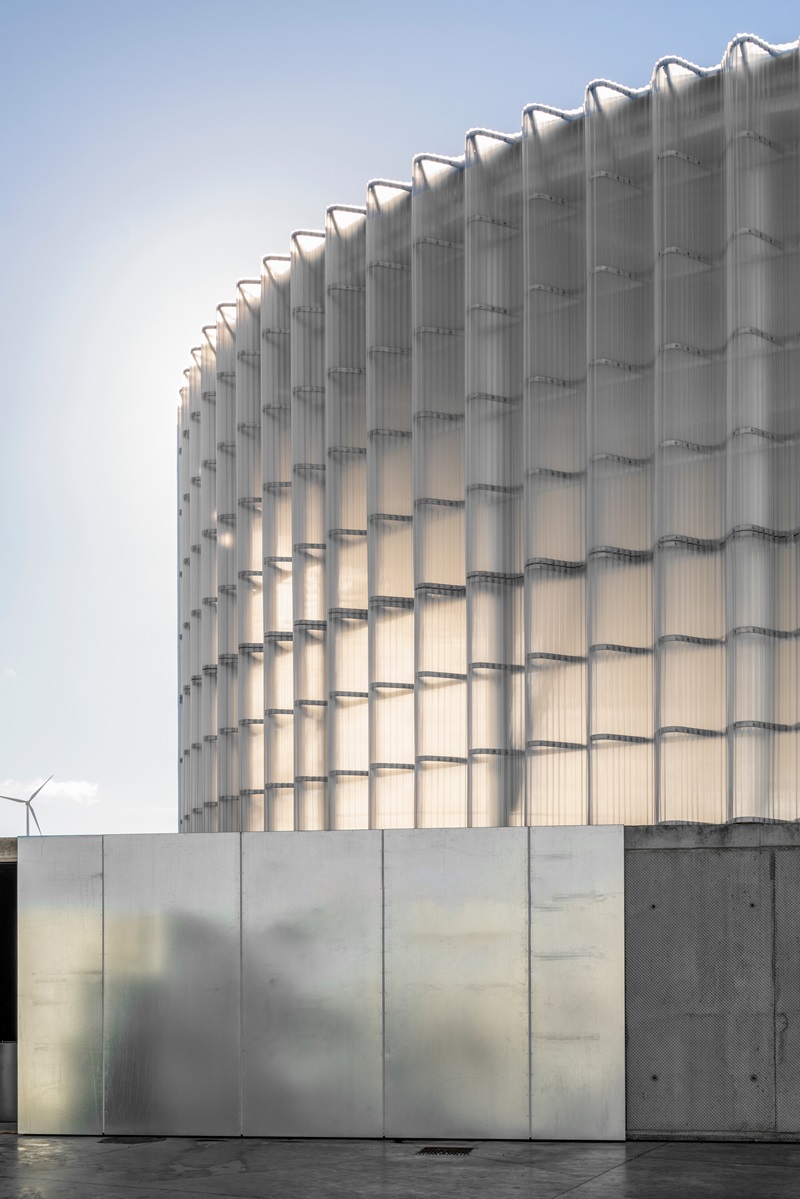 frpo-dh-palencia: fachada translúcida de policarbonato minionda con iluminación artificial