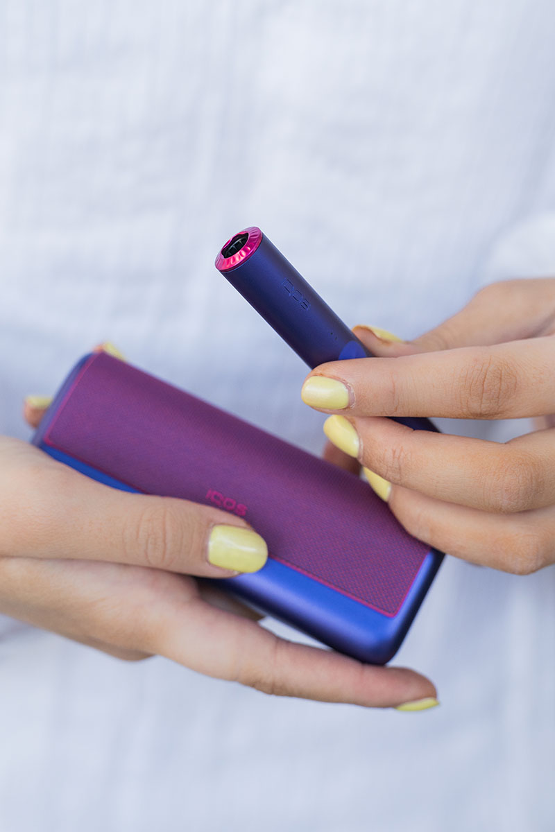 Iqos Ilumia Neon Purple: una chica sujeta un kit de esta edición limitada