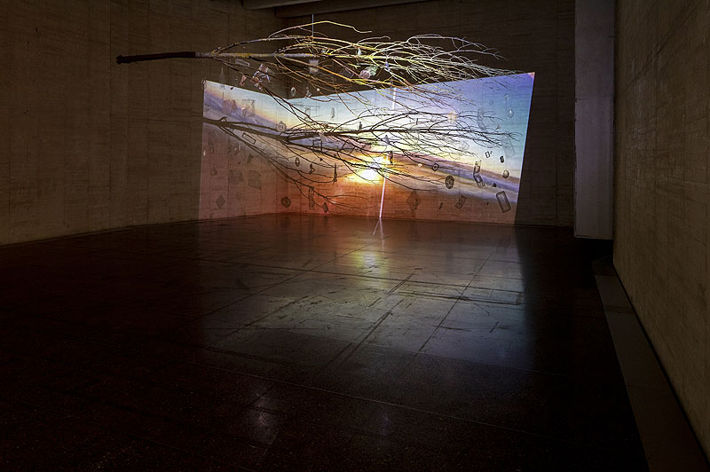 musac - imagen de una gran sala de museo con paredes de hormigón , una proyección sobre un arbol colgado del techo