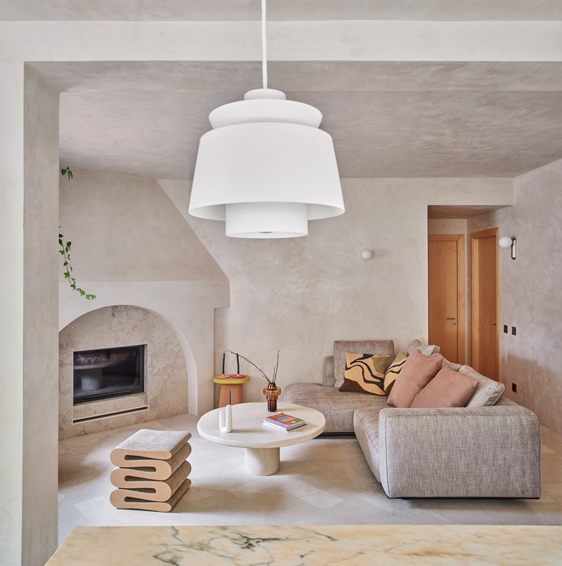 Casa-Montesa-Kresta-Design: salón en tonos neutros con gran chimenea y sofá