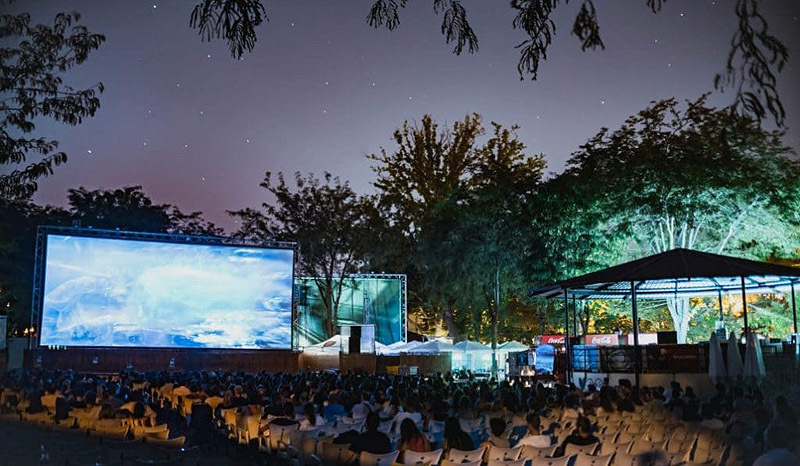 Cine de verano, imagen de publico viendo una pelicula al aire libre