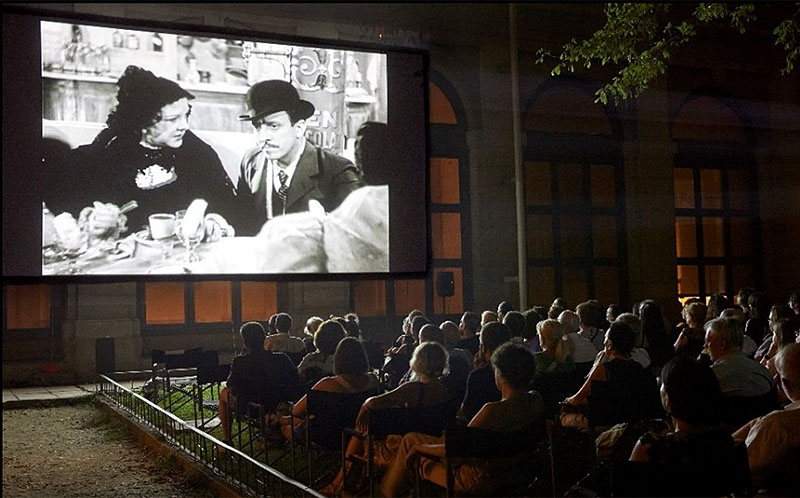 Cine de verano, imagen de publico viendo una pelicula al aire libre