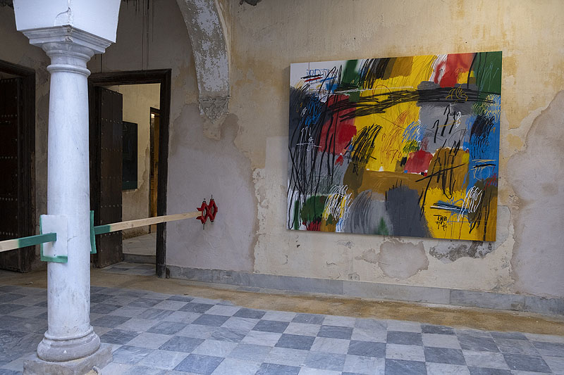 Del grano a la montañA - vista de la instalación artística de SRGER, cuadros de garabatos de colores y otras piezas en un palacete antiguo y devencijado