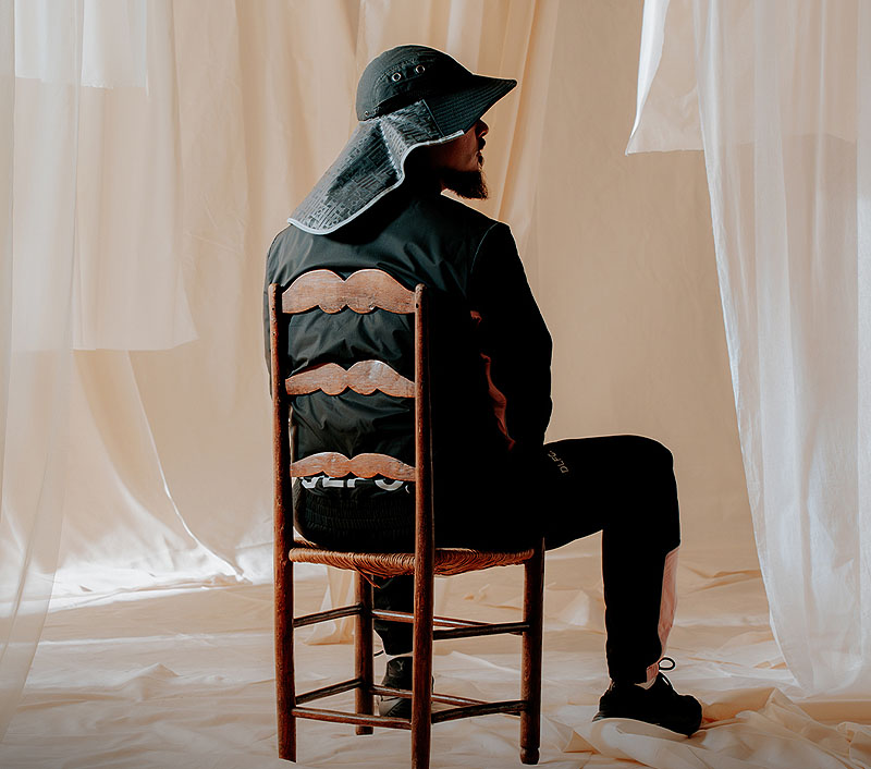 Dellafuente - El camino a la montaña - retrato del artista sentado en una silla entre cortinas transparentes
