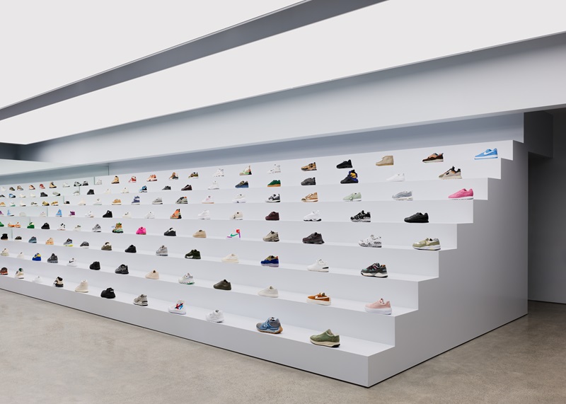 Heliotrope-Architects-Likelihood: tienda con graderío de color blanco repleto de zapatillas de deporte