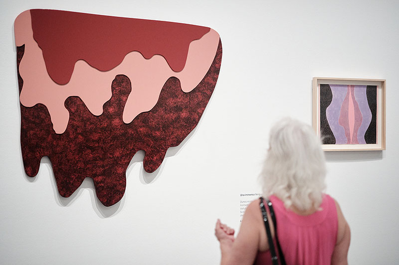Mari Chorda, una persona en una sala de exposición con pinturas y esculturas de mucho color