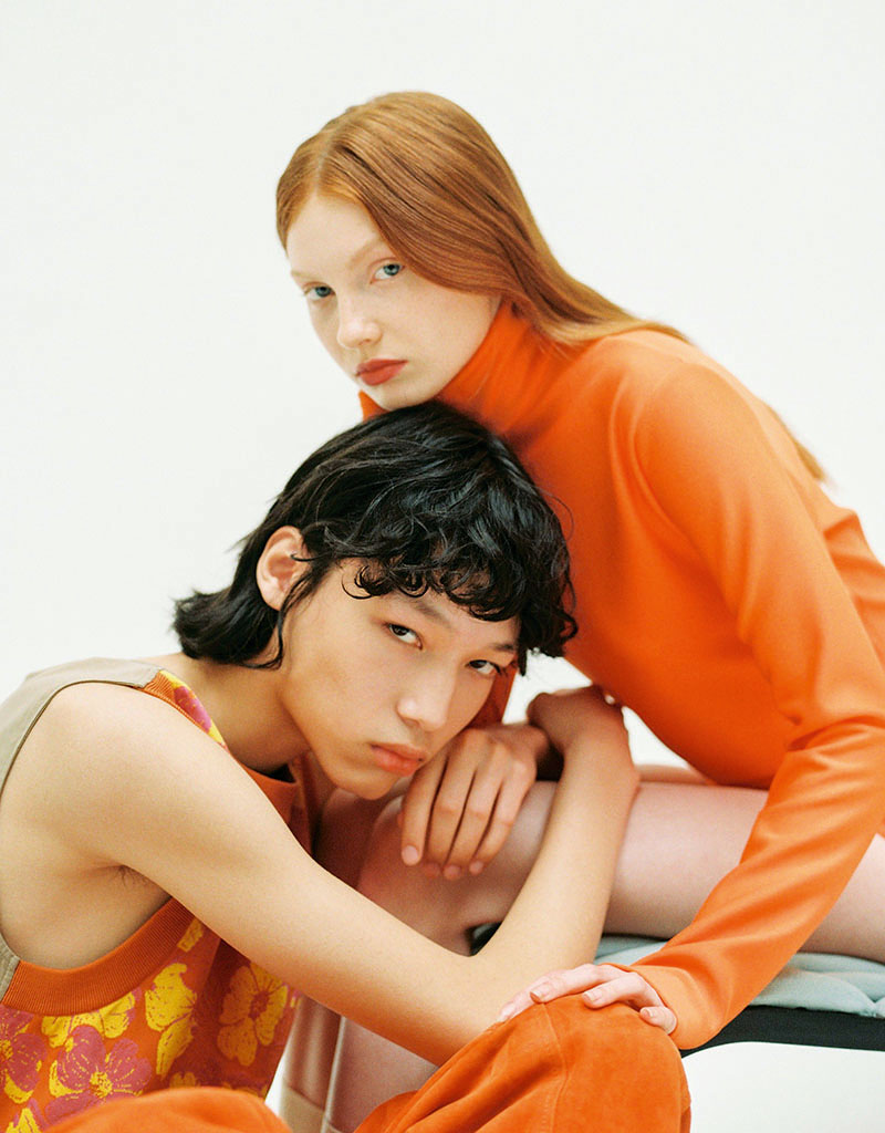 Editorial mobiliario y moda Back on 74: la pareja de modelos vestidos en tonos naranjas