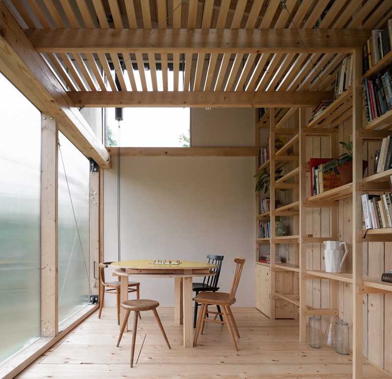 byro-architekti-garden-pavilion: pabellón de interior de madera con zona de estar repleta de estanterías