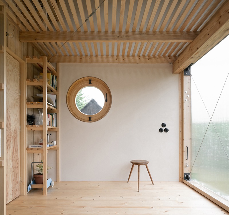 byro-architekti-garden-pavilion: pabellón de interior de madera con zona de estar con ojo de buey