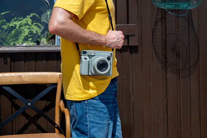 Instax Wide 400 Fujifilm: un hombre lleva esta cámara colgada del hombro