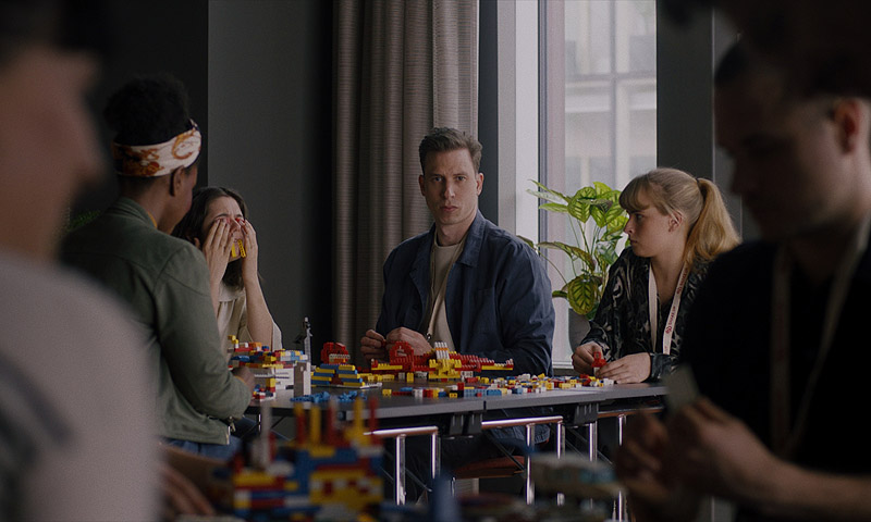 Hipnosis - fotograma de la película, en la imagen se ve a un grupo de personas montando juguetes de Lego