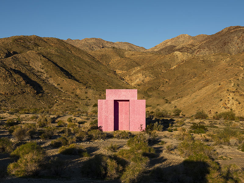 Edificio rosa en medio de paisaje desierto