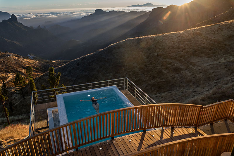 Lugares en España instagrameables: una mujer se baña en lo alto de una montaña con unas vistas alucinantes al atardecer