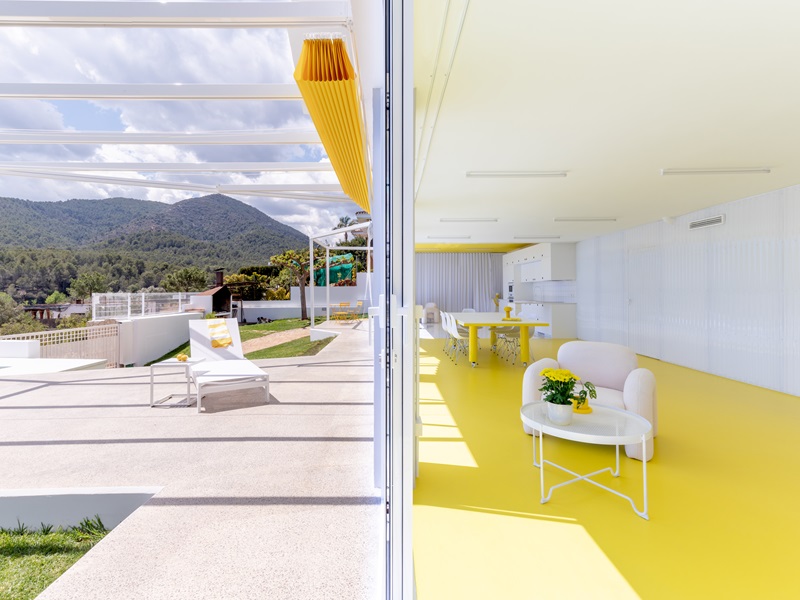 Pepelacruzarch-Bodega-tecno-social: espacio multifuncional amarillo con vistas a la sierra