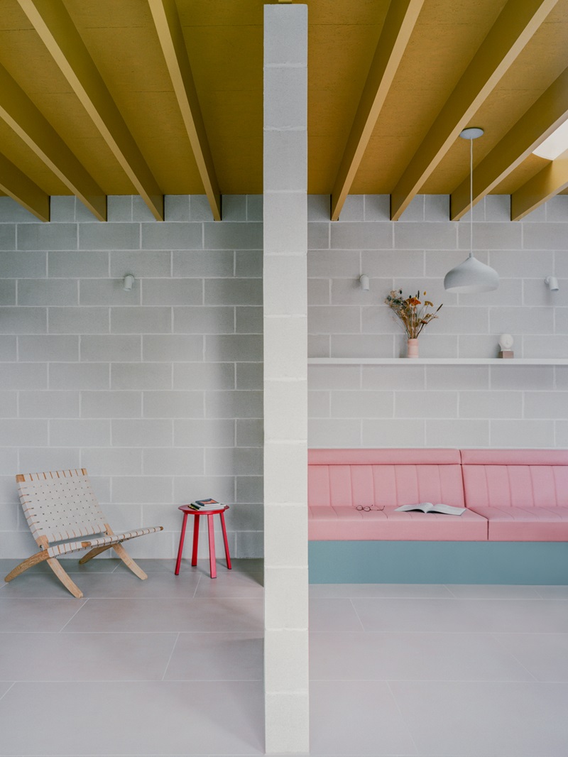 Triangle-House-Artefact: comedor con sofá rosa y techo dorado