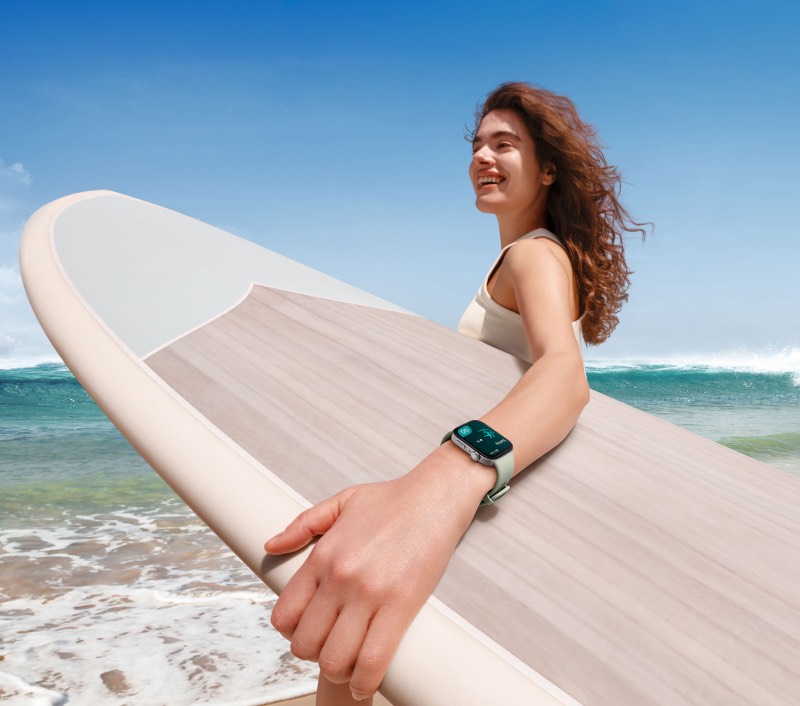 Huawei Summer Wave: una chica con una tabla de surf en la orilla lleva el WATCH FIT 3 Sport Edition