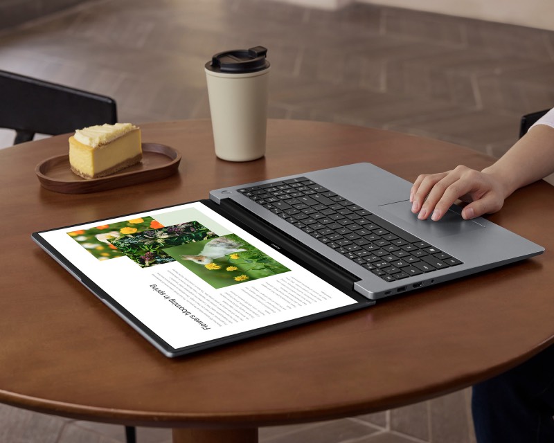 Huawei Summer Wave: portátil MATEBOOK D 16 2024 abierto y encendido sobre una mesa de madera que tiene una bebida y una porción de tarta