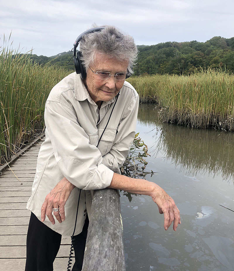 32 Sounds - fotograma de la película documental, se ve a una abuela en un lago con auriculares