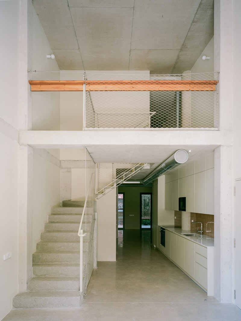 Atienza-Maure-Sardenya-356: salón-cocina de sobre altura con escalera blanca y viga naranja