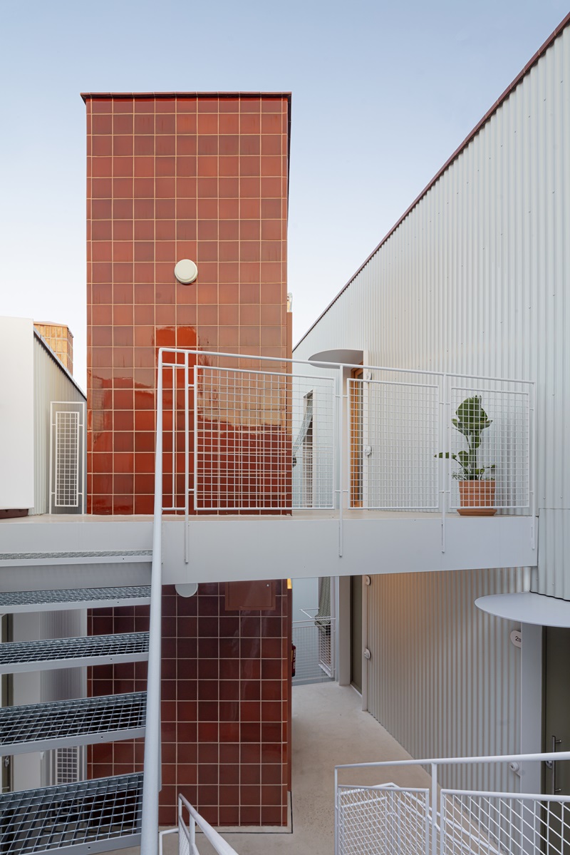 Be-Studio-Churruca: escaleras blancas metálicas y torre de azulejos de cerámica roja