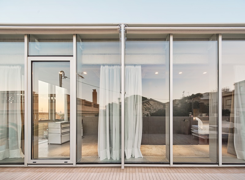 Claudia-Raurell-Villain-House: muro cortina con perfiles de de aluminio adonizado