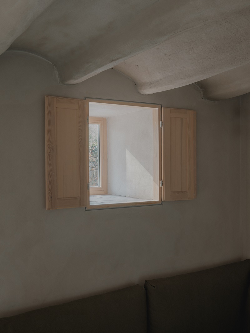 House-in-the-woods-Andrea-Joan-Arquitectes: ventana pequeña de madera y bovedilla blanca