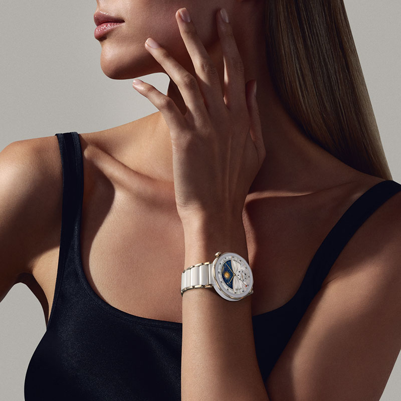 Huawei Watch GT 5 Pro: plano detalle de la mano y torso de una mujer que lleva el reloj inteligente Huawei Watch GT 5 Pro de cerámica en blanco