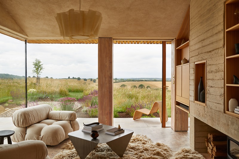 Hutch-Design-Makers-Barn: salón con sillón y mullida alfombra y vistas al campo