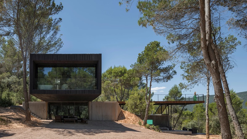 Ignacio-Borrego-Casa-Embarcadero: volumen negro de hormigón con pasarela de madera