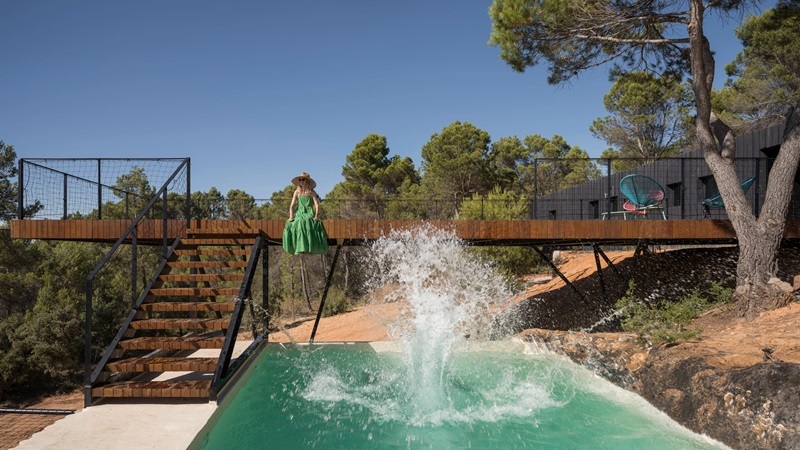 Ignacio-Borrego-Casa-Embarcadero: pasarela de madera con piscina y vistas al bosque de pinos