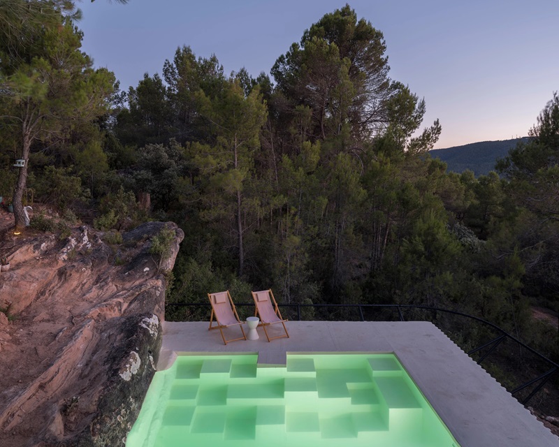 Ignacio-Borrego-Casa-Embarcadero: piscina de hormigón blanco con vistas al bosque de pinos