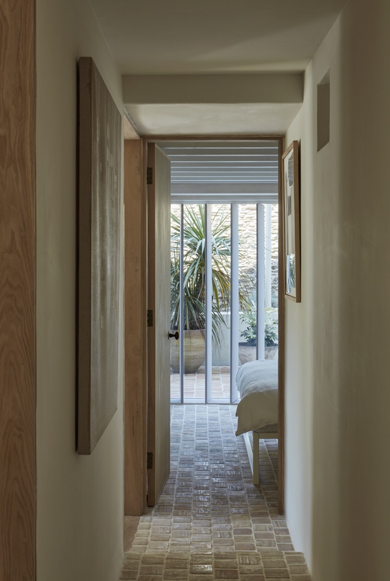 Tuckey-Design-Studio-The-Old-Chapel: dormitorio con puerta de cristal al patio y pasillo