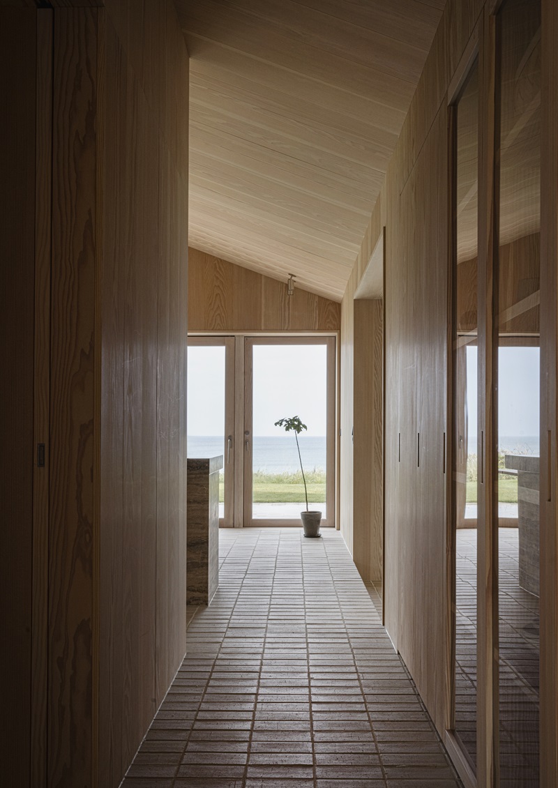 Norm-Architects-Heatherhill-Beach-House: sala de estar de madera con vistas al mar