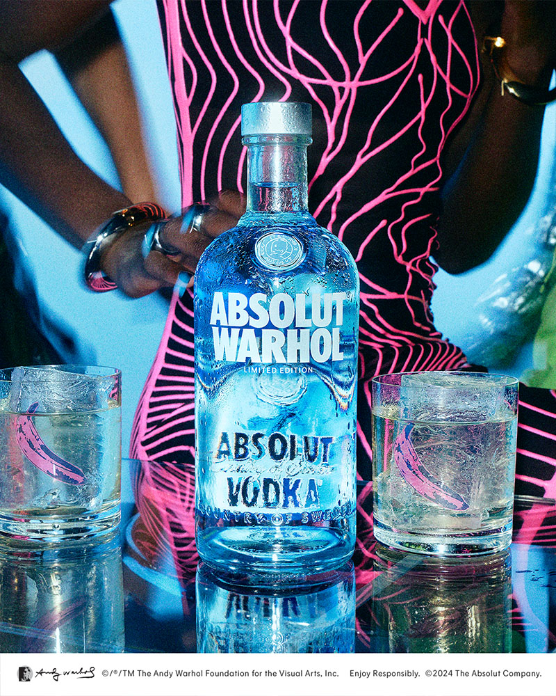 Absolut Warhol: cartel publicitario de la botella edición limitada Absolut Warhol con un cóctel a cada lado en una sala de fiesta.